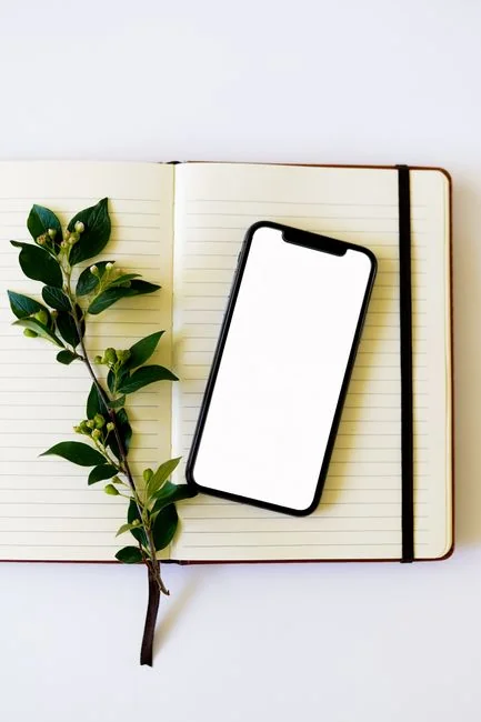 services-02 Gros plan d'un carnet avec des esquisses de wireframe et un smartphone posés sur un bureau en bois.